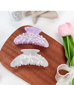 Detailed view of elegant marble acrylic hair claws with pearl flower and rhinestone accents