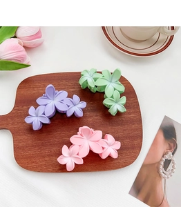 Vue détaillée de trois pinces à cheveux fleurs mates en violet, vert et rose pastel