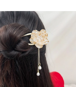 Close-up of elegant peony hair pin with white petals and gold-plated pearl tassels
