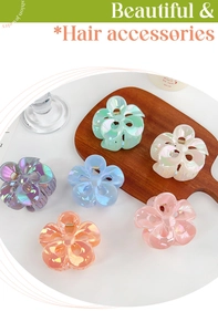 Iridescent flower claw clips in six candy colors arranged on a minimalist wood tray