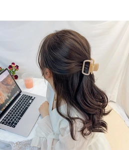 Vue détaillée d'une grande pince à cheveux en acétate crème avec découpe rectangulaire