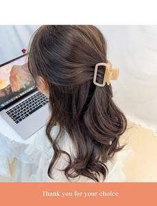 Gros plan d'une pince à cheveux rectangulaire crème portée dans un cadre quotidien chic