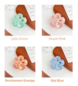 Detail view of colorful floral hair claws in emerald green, peach pink and sky blue colors
