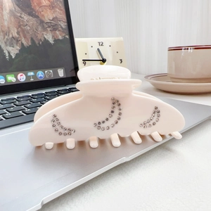 Eleganter Haarklammer aus Acetat in Creme mit Strass-Mondsichel auf dem Laptop