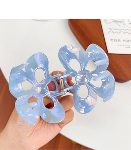 Macro shot of large blue iridescent plumeria hair claw clip with pearlescent finish