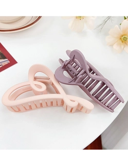 Close-up of heart-shaped hair claw clips in peach and mauve with matte texture