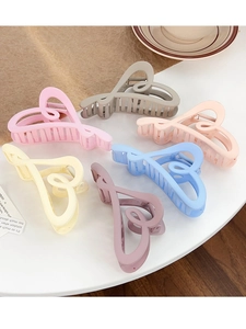 Set of 6 colorful heart-shaped hair claw clips in macaron colors on a white table