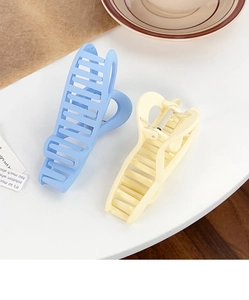 Close-up of matte candy-colored heart claw clips in pastel blue and cream shades