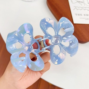 Elegant iridescent blue plumeria hair claw clip with a glossy hollowed-out shark clip design