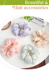Close-up of four floral fabric hair claws in pastel purple, beige, pink and light green