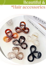 Top view of elegant bow-shaped hair claws in six colors displayed on a white round table