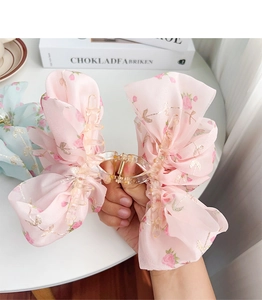 Detail of pink floral chiffon bow hair claw clip with gold embroidery and clear frame