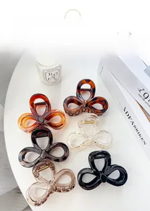 Set of large elegant bow hair claws in various colors displayed on a bright desk