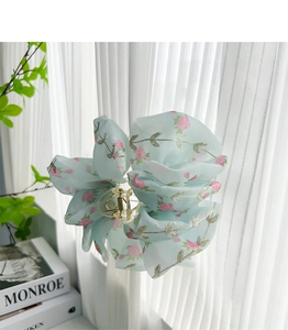 Detail of light blue floral lace hair claw clip with embroidered roses and metallic spring
