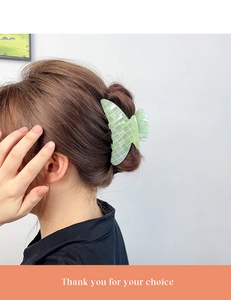Détail de la pince à cheveux à damier vert clair portée sur les cheveux d'une femme