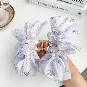 Floral fabric bow hair claw clip in purple and blue patterns for elegant styling