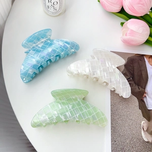 Lot de pinces à cheveux irisées aux couleurs bonbon en bleu, blanc et vert sur la table