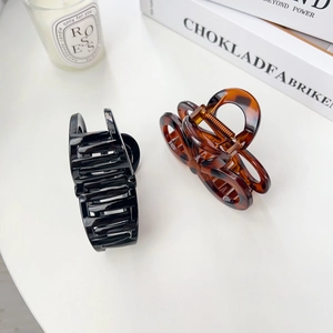Elegant bow-shaped hair claws in black and tortoiseshell finish for thick hair