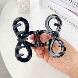 Elegant glossy black bow hair claw clip with minimalist double-loop design for women