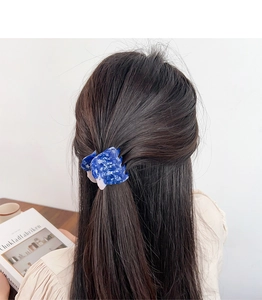 Blue marble texture acetate hair claw clip showing elegant wavy design on model's hair
