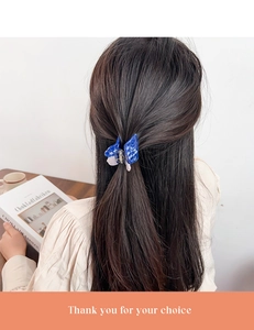 Blue butterfly hair claw clip with marble texture shown on a ponytail hairstyle
