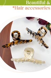 Three large acetate hair claw clips in tortoise, leopard, and marble patterns on display