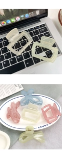 Close-up of matte acrylic square hair claws in pastel tones on a decorative tray