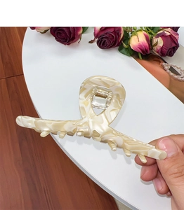 Detail showing marble texture acetate hair claw clip with strong metal spring