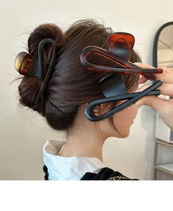 Grandes pinces à cheveux croisées de couleur noir mat et ambre effet écaille de tortue