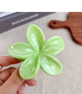 Dettaglio della molletta per capelli a fiore verde chiaro con motivo marmorizzato bianco
