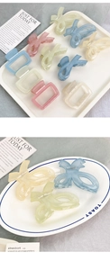 Macro shot of colorful translucent butterfly and square resin hair claws in soft pastel tones