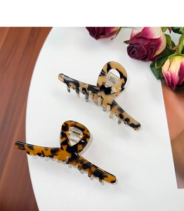 Detail view of two tortoiseshell hair claws in dark and light brown acetate finish