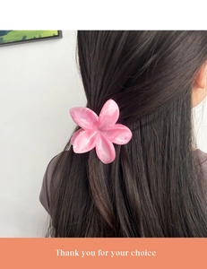 Pinza per capelli a forma di fiore rosa marmorizzato indossata per acconciatura