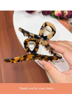 Detailed view of large brown tortoiseshell hair claw clip with strong metal spring