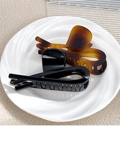 Ensemble de pinces à cheveux élégantes noires et ambrées sur une assiette en céramique