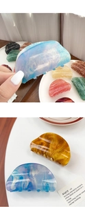 Detailed close-up of glitter marble acrylic hair claw clips with various trendy colors