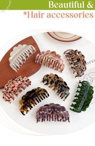 Flat lay of eight stylish acetate hair claws in various marble and tortoiseshell patterns