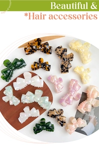 Various acetate bow hair claw clips in tortoise, marble, and pearl finishes on display