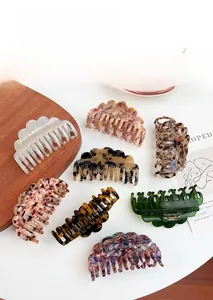 Macro detail of assorted large cellulose acetate hair claws in seven elegant patterns