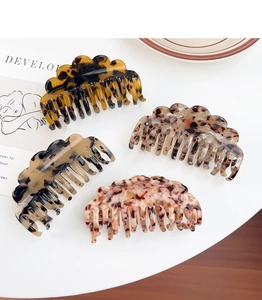 Detail of acetate claw clips with tortoise shell texture and wavy edges in four colors