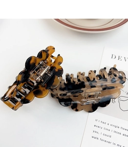 Detail of tortoise shell acetate claw clips with double row teeth and wavy petal design