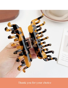 Detail showing the leopard print pattern and metal spring on this acetate hair claw clip