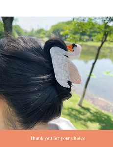 Detail view of elegant swan hair claw clip in pearlescent acetate worn in nature