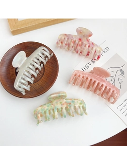Detailed close-up of premium acetate hair claws in various elegant patterns and colors