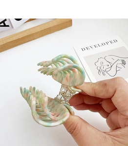 Detail of premium marble pattern acetate hair claw clip with colorful swirl finish