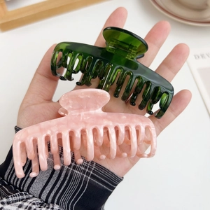 Acetate hair claws in dark green and pink marble finish for thick hair styling