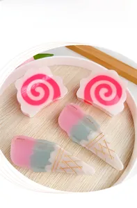 Macro detail of dopamine pink swirl and ice cream cone acetate hair claws on a tray