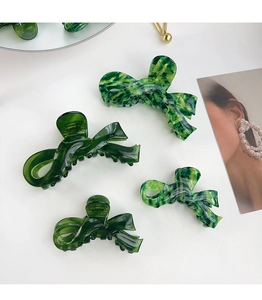 Close-up of acetic acid butterfly hair claws in green marble and solid textures
