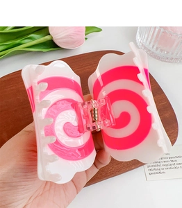 Close-up of pink and white spiral acetate hair claw clip with wide-tooth design