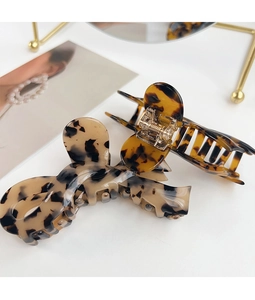 Close-up of tortoise shell pattern texture and durable metal spring on large hair claw clip